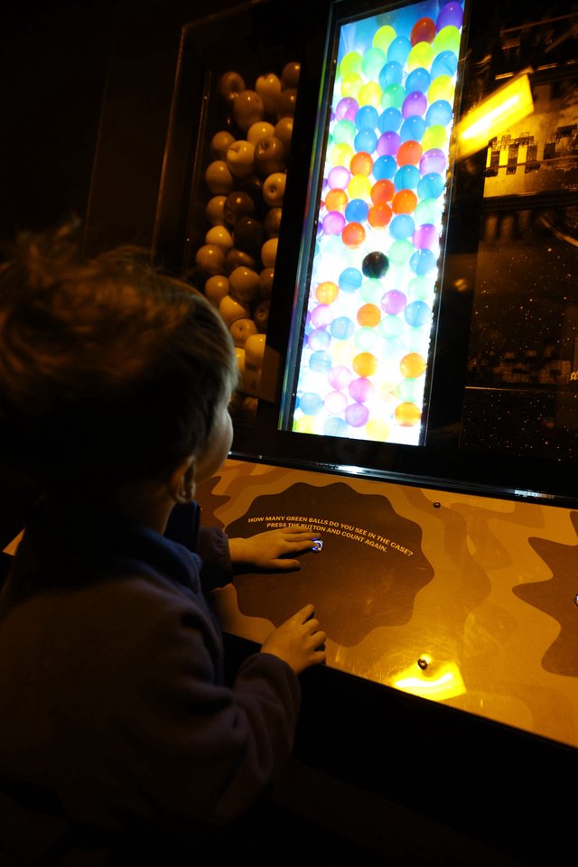 Child Playing Interactive Ball Counting Game at Science Museum