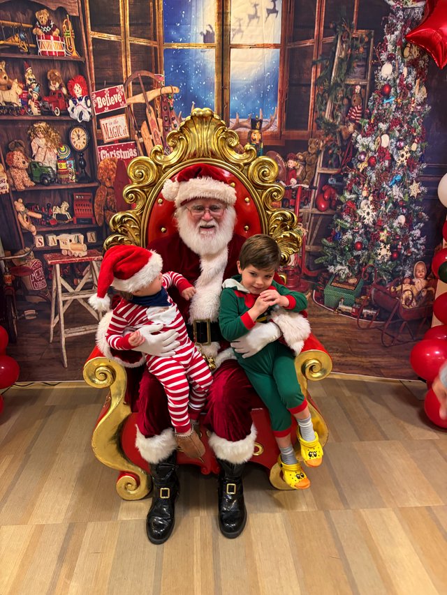 Two Children Visit Santa in His Workshop Grotto