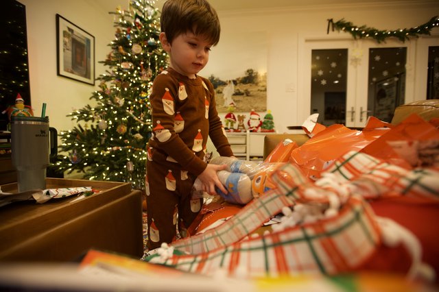 Young Child Opening Christmas Presents on Christmas Morning