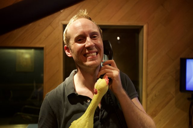 Man with Yellow Stuffed Animal in Recording Studio