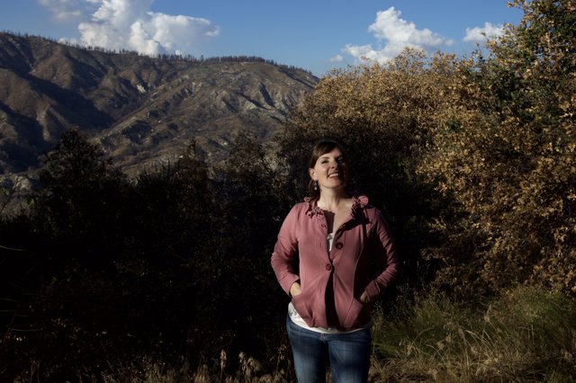 Woman Smiling Against Burnt Mountain Landscape