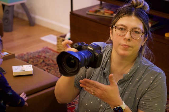Videographer Showing Camera in Home Studio Setting