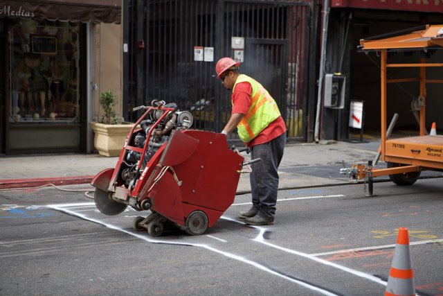 Street Worker Operating Red Machine