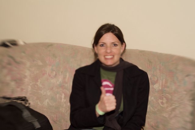 Woman Smiling on Floral Couch Holding Microphone