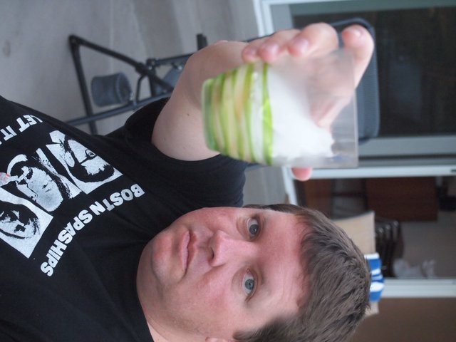 Upside Down Man Holds Green-Striped Drinking Glass