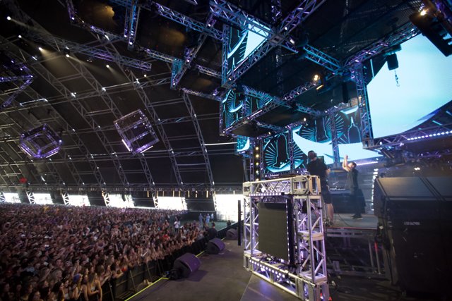 The Epic Stage Show Caption: The massive stage, blazing lights and thundering crowd make for an unforgettable concert experience at Coachella 2016.