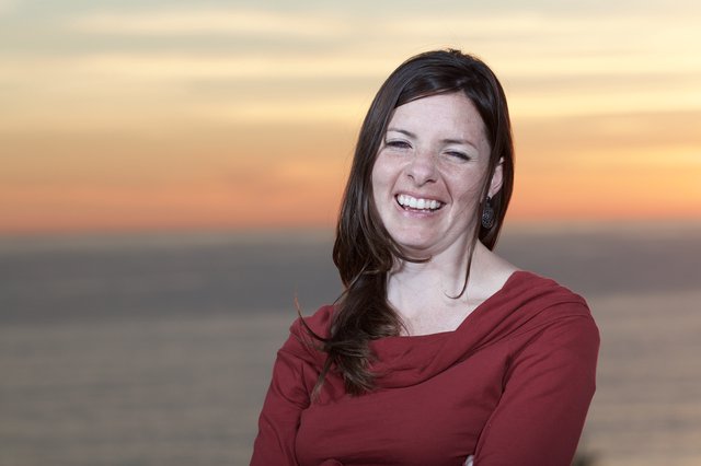 Joyful Woman Laughing at Coastal Sunset