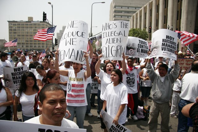 Protest in the Streets Caption: Shōgo Hamada and Pancho Villa join a crowd of 35 people holding signs and flags during a parade protest in 2006.