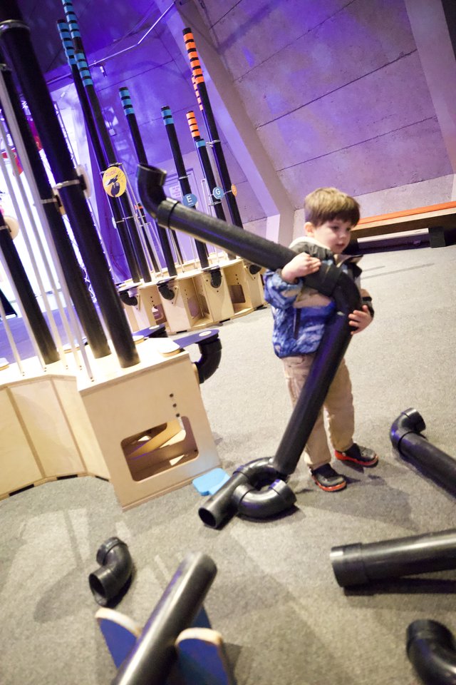Child Playing with Pipes at Interactive Museum Exhibit