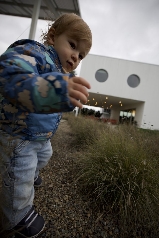 Young Child Playing Giant at Modern Building
