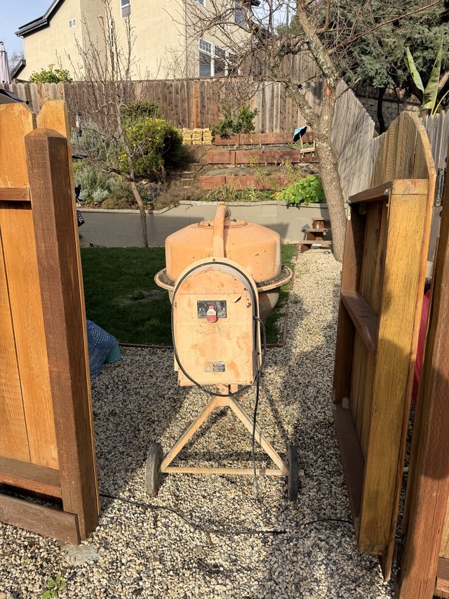 Vintage Orange Cement Mixer in Suburban Backyard