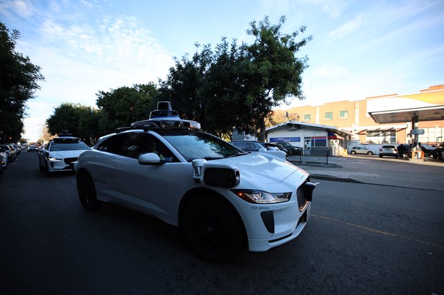 Autonomous Waymo Vehicle on Urban Street at Dusk