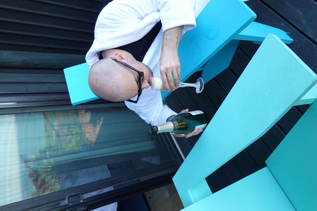 Man Enjoying Champagne on Turquoise Outdoor Furniture