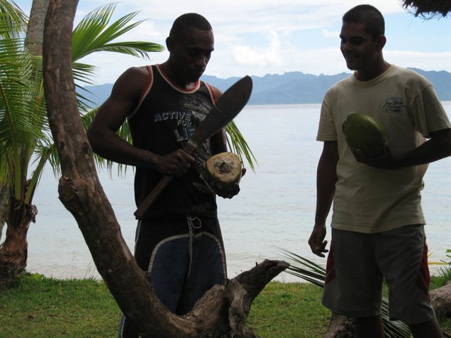 Two Men Enjoying Fresh Coconuts in Fiji