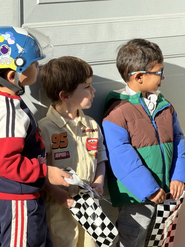 Young Racing Fans with Checkered Flags and Costumes