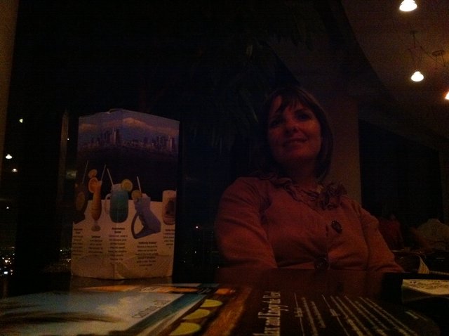 Smiling Woman at Dimly Lit Restaurant Table