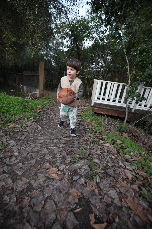 Young Boy Playing Basketball in Backyard Garden