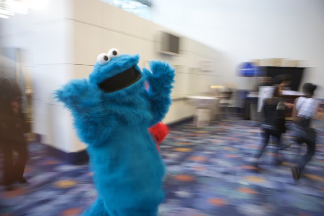 Blue Cookie Monster Mascot Poses with Three People at 2008 NAMM Event