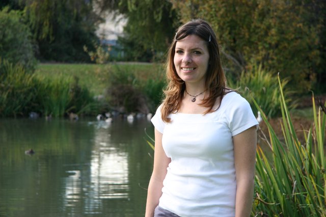 Smiling Woman by a Peaceful Park Pond