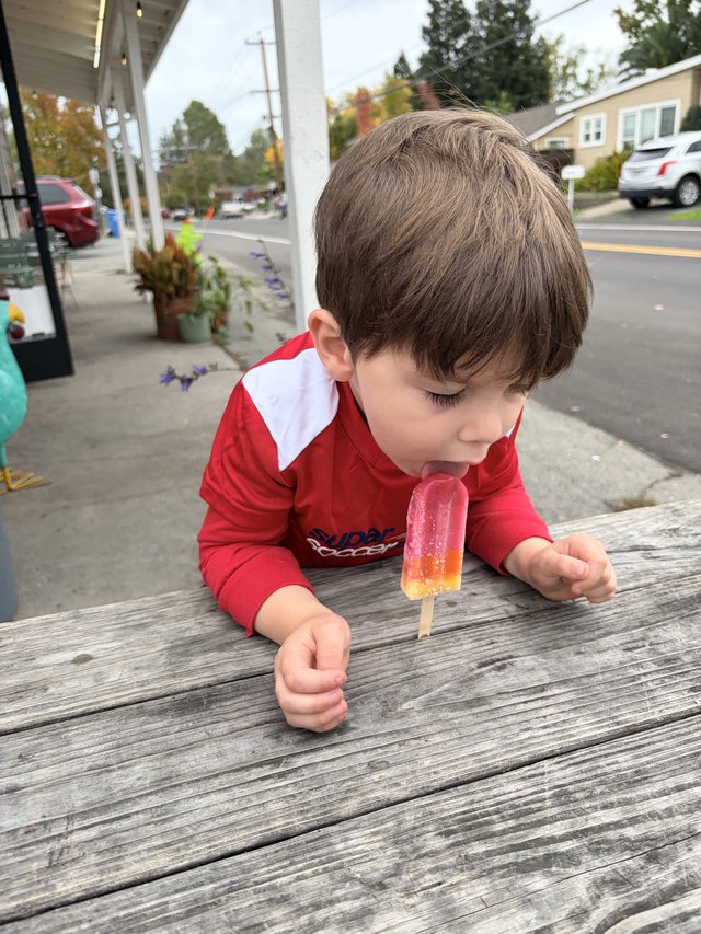 Young Boy Enjoying a Popsicle on a Small Town Street