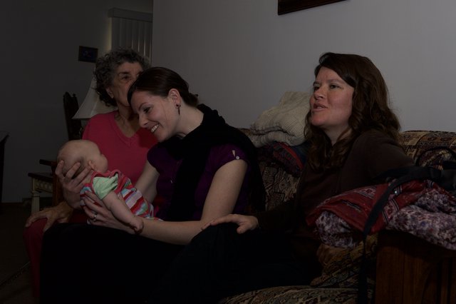 Three Generations Share a Tender Moment with Newborn