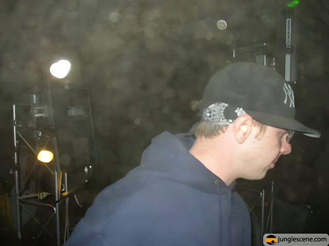 Man in Blue Hoodie and Baseball Cap with Microphone
