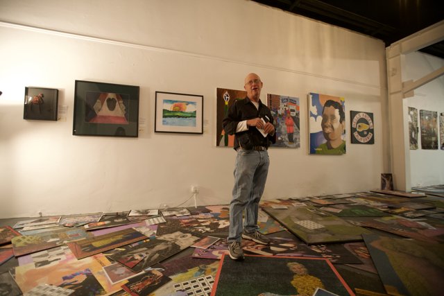 Man Admiring Paintings on Gallery Floor