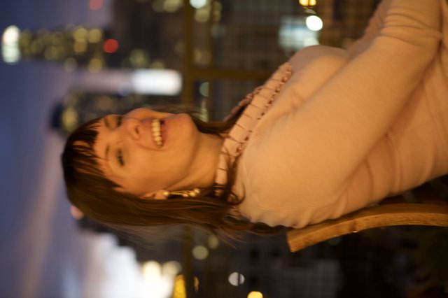 Laughing Woman Against City Skyline at Dusk
