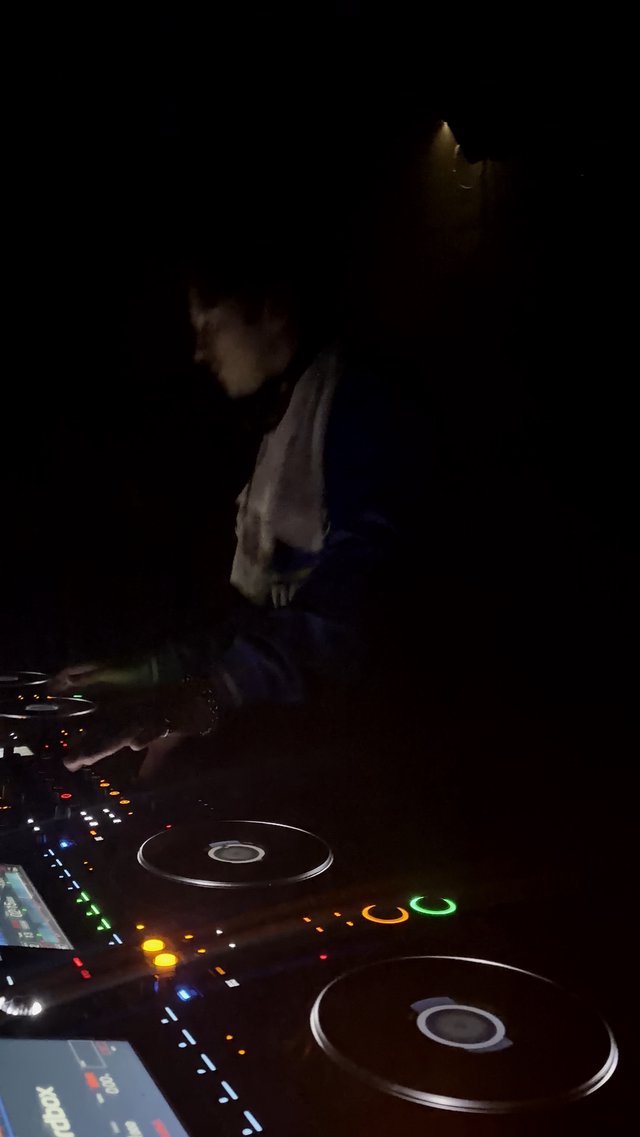 DJ Performing in Dimly Lit Club at Night