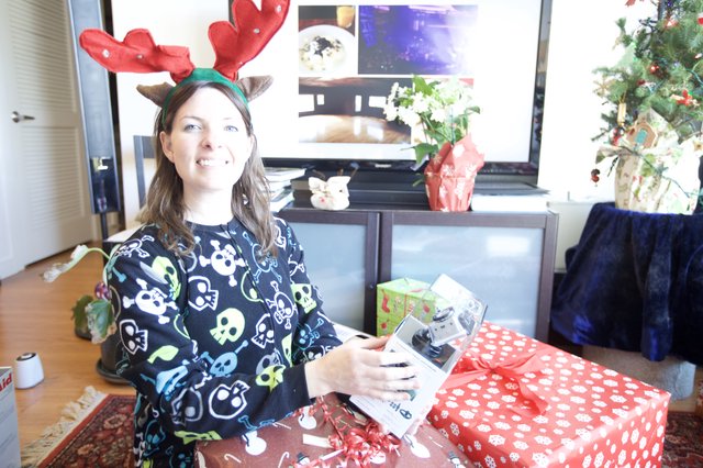 Joyful Christmas Morning Gift Unwrapping with Reindeer Antlers
