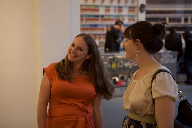 Two Women Sharing a Joyful Conversation at Gallery Event