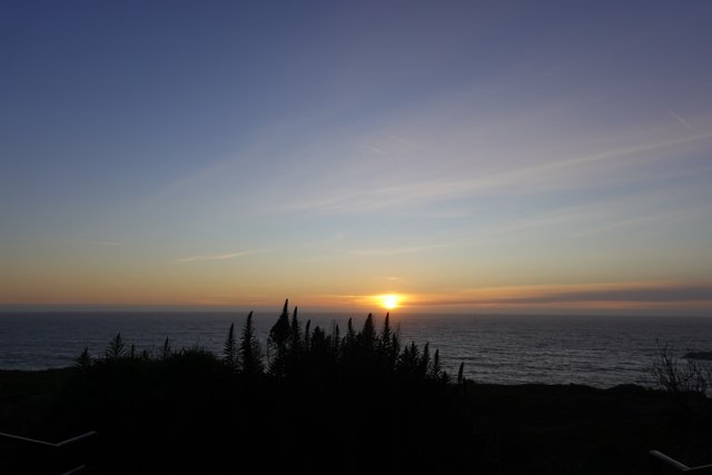 Hillside view of a stunning sunset over the ocean