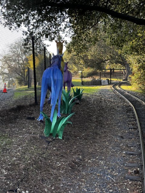 Blue Horse Statue on a Path Next to the Train Tracks