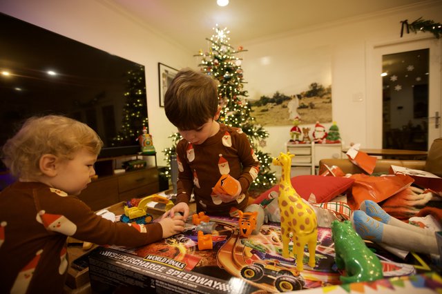 Brothers Opening Christmas Presents Together at Home