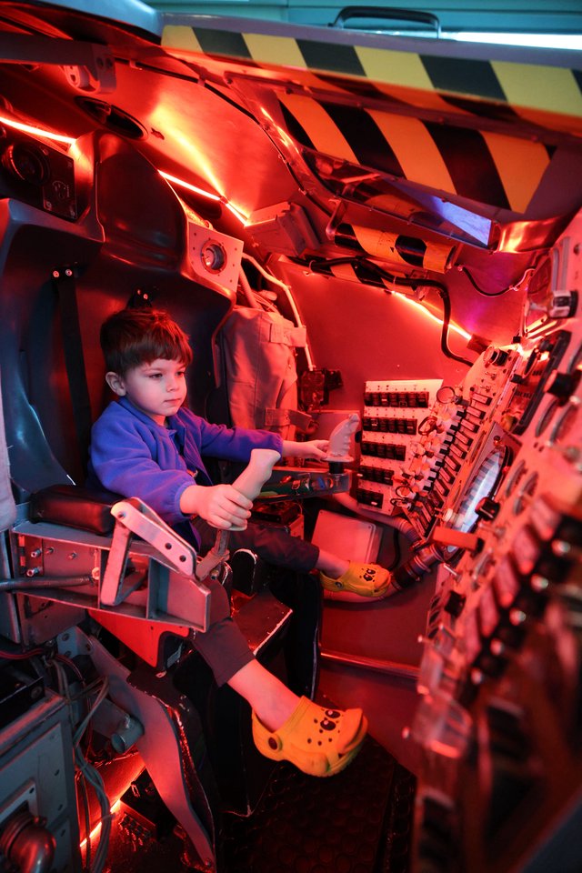 Young Pilot in Illuminated Aircraft Cockpit Simulator