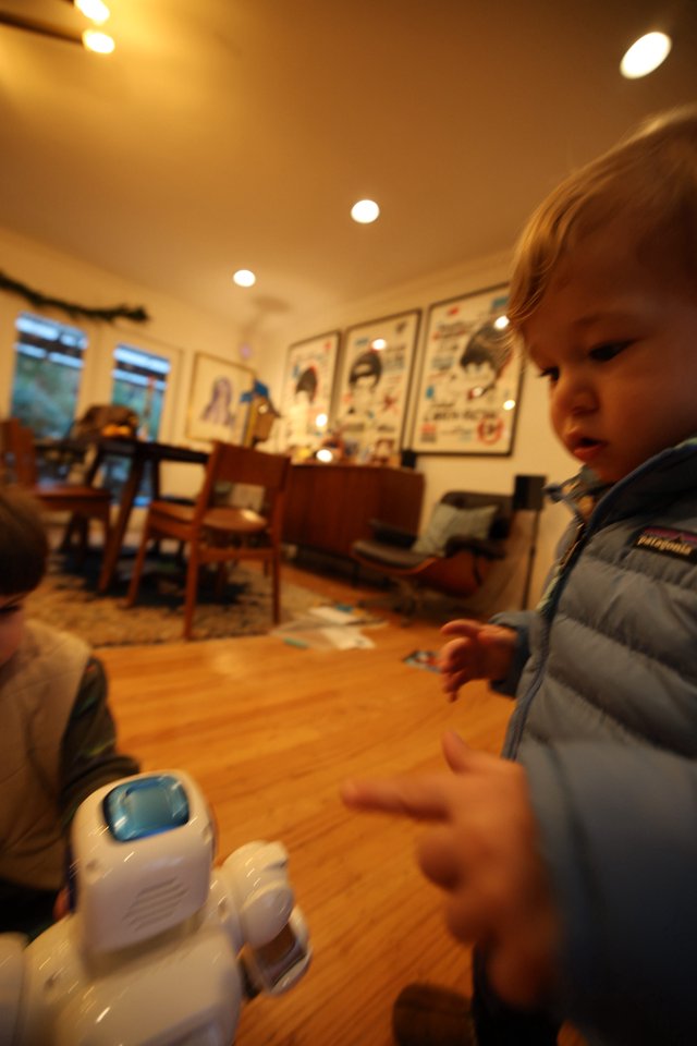 Young Child Playing with Toy Robot at Home