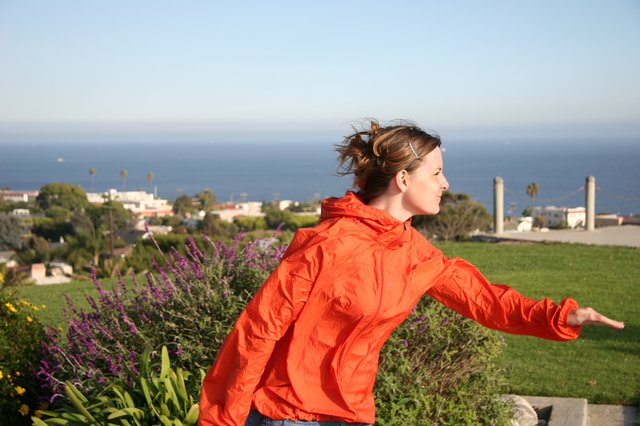 Woman in Red Jacket Embracing the Ocean Breeze
