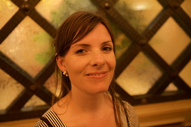 Smiling Woman Framed by Ornate Lattice Window