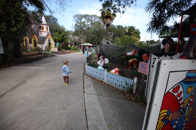 Child Exploring Storybook-Themed Miniature Village at Dusk