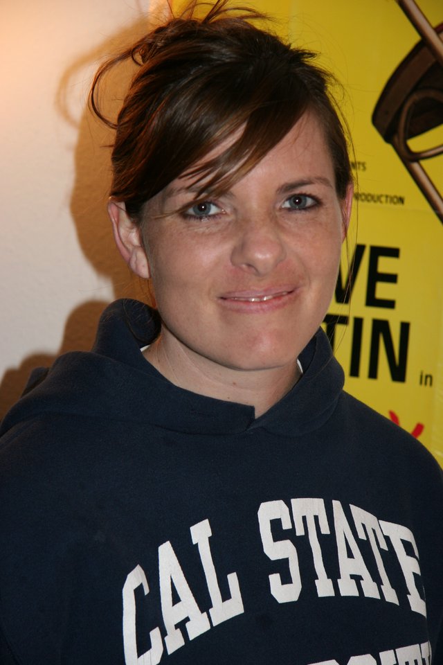 Woman in Cal State Hoodie at Event Backdrop