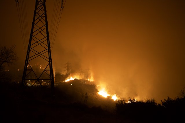 Flames Threaten Power Lines on Hillside