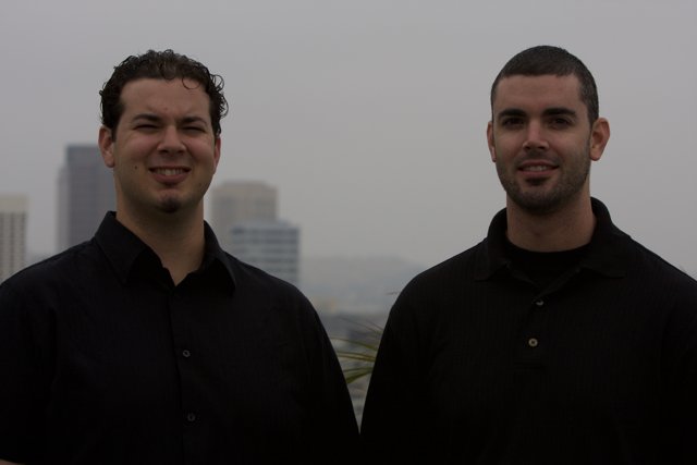 Two Happy Men in Black Shirts Posed Outdoors