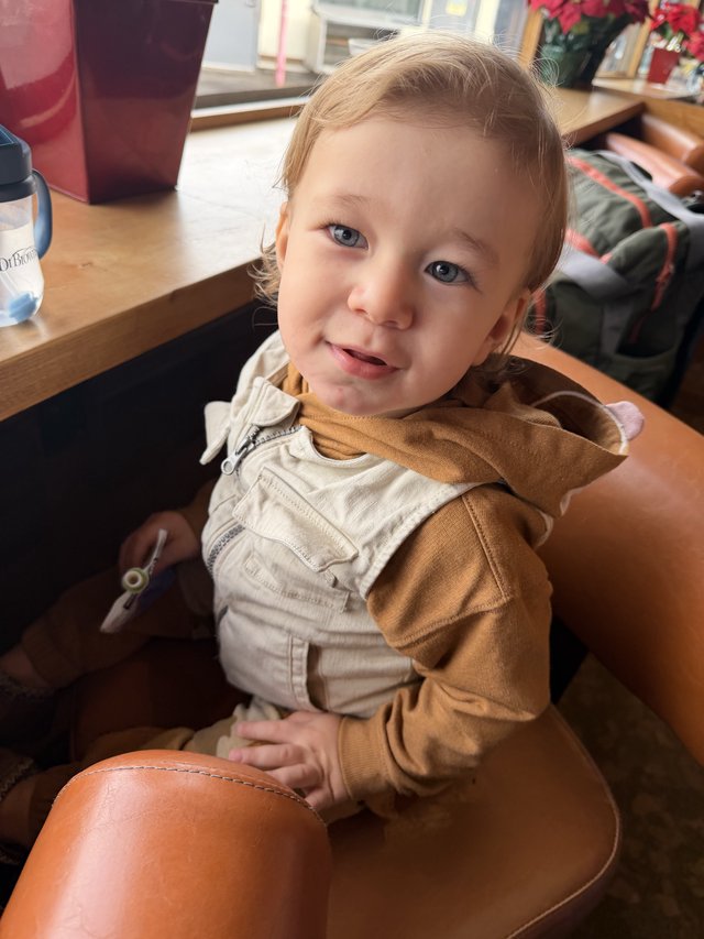 Cheerful Toddler in Beige Overalls at Home