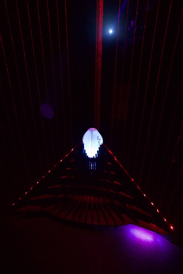 Illuminated Skull Installation in Dark Corridor with Red Laser Grid