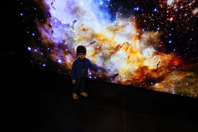 Child Explores Cosmic Nebula at Space Center