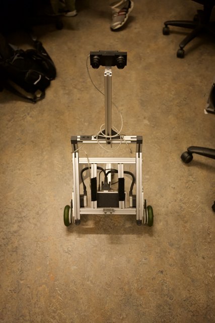 Robot and Computer on Wooden Floor