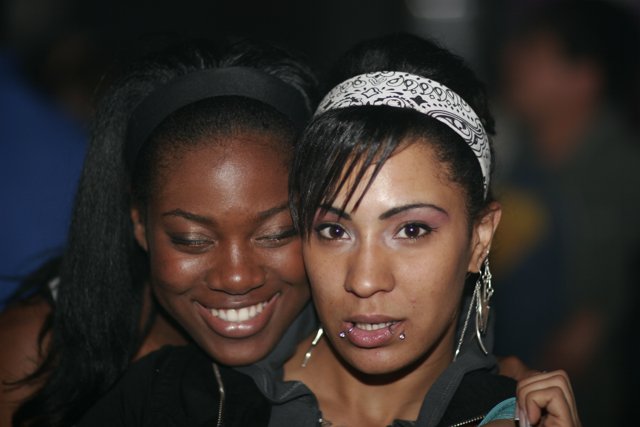 Two Women Flaunting Their Headgear with Smiling Faces