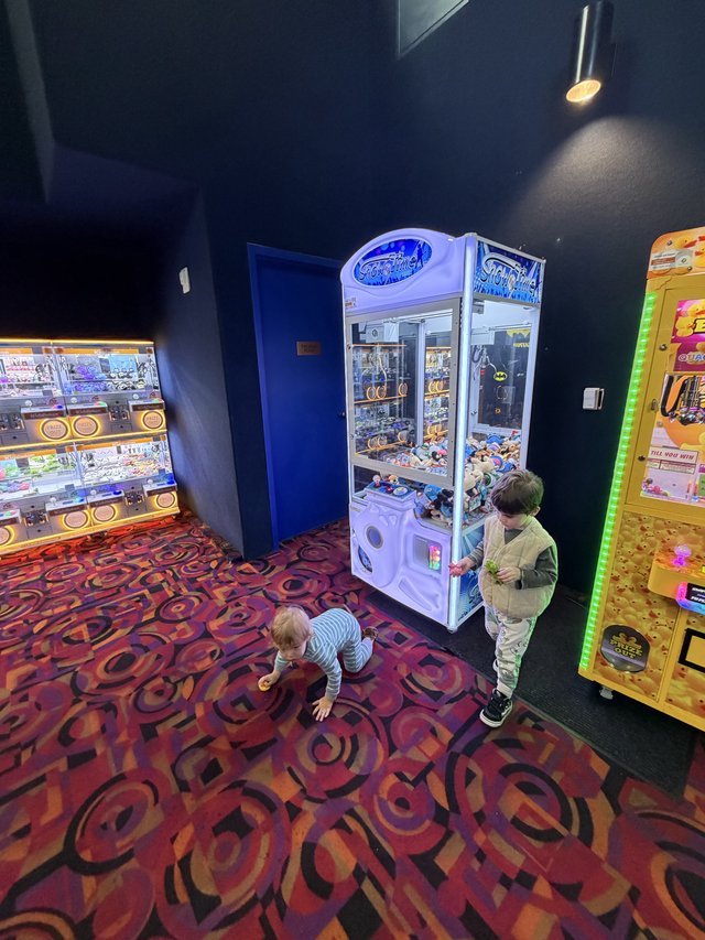 Children Playing at Arcade Claw Machine Area
