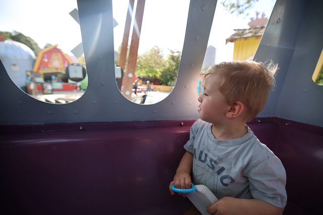 Toddler Gazing Through Playground Portal Window