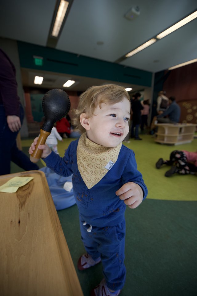 Joyful Toddler Playing with Toy Mallet Indoors